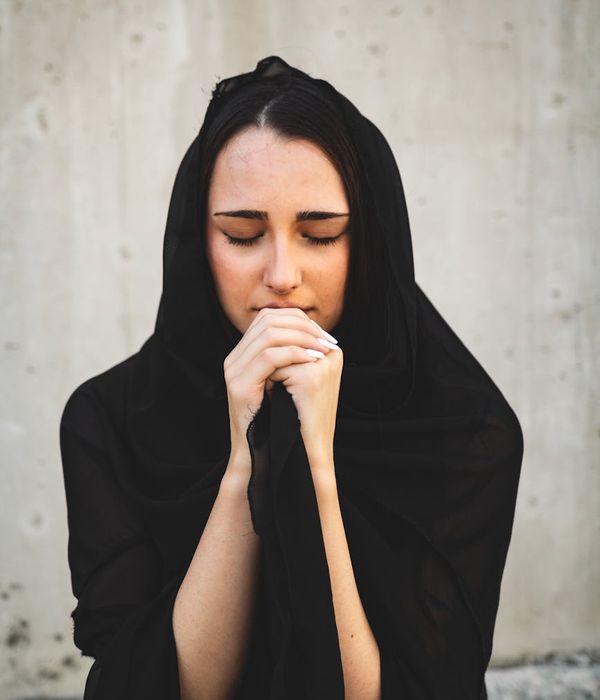 A calm woman with closed eyes, focusing inward in a serene environment.