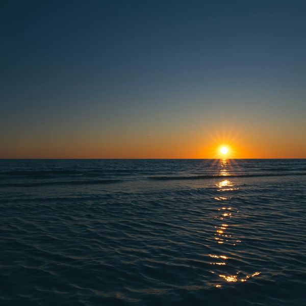 Smiling person meditating outdoors in a beautiful natural setting.